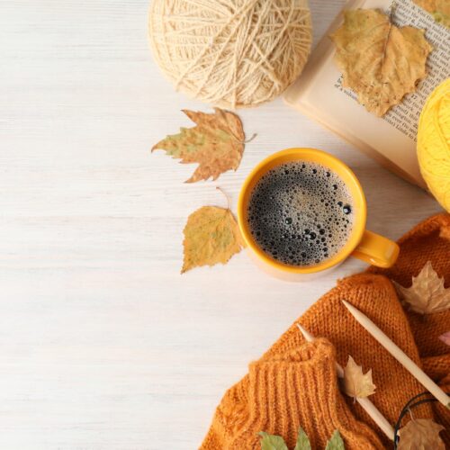 Concept of autumn with yarn balls on white wooden background